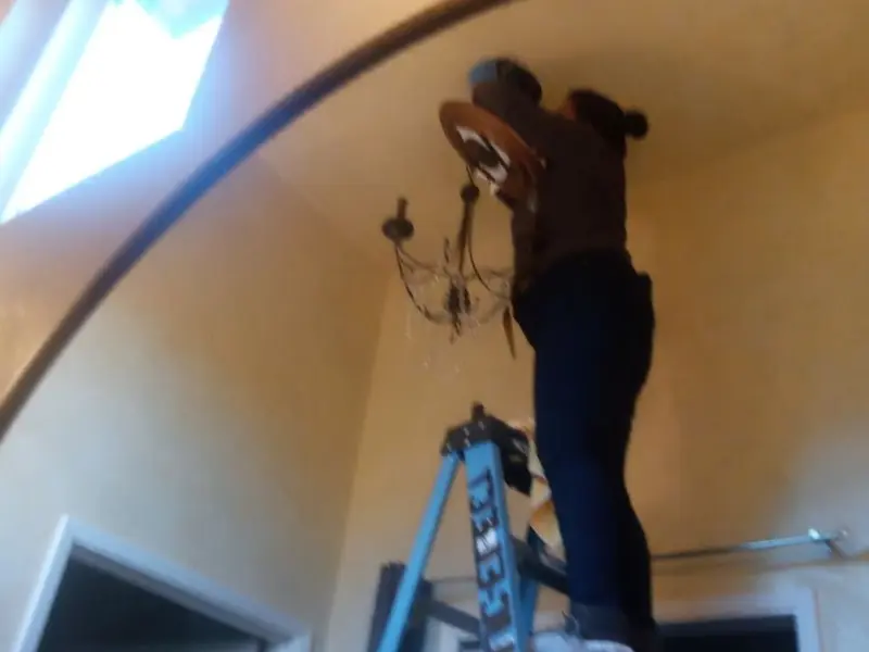 Electrician installing a chandelier in a Sewanee residence